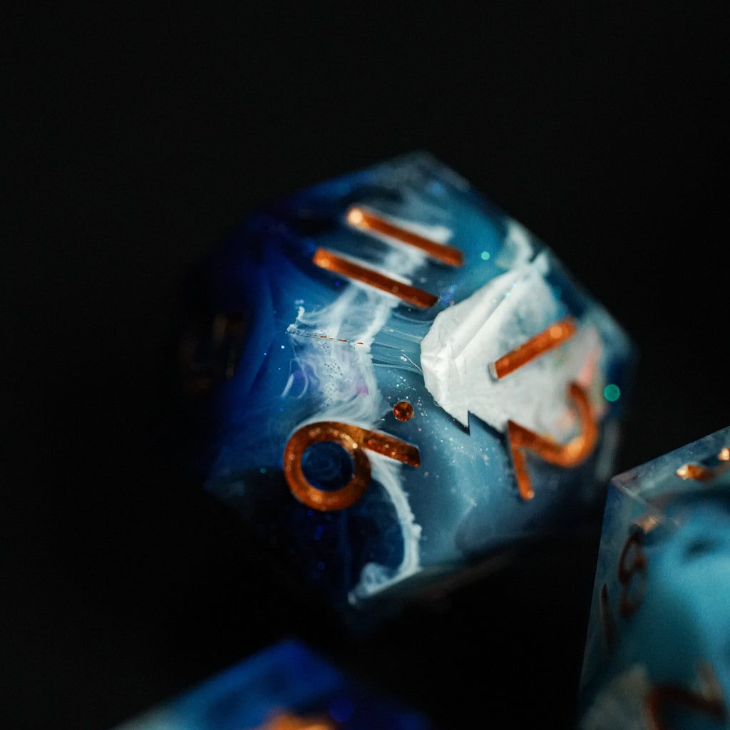 Close-up of a blue and orange die with a dark background