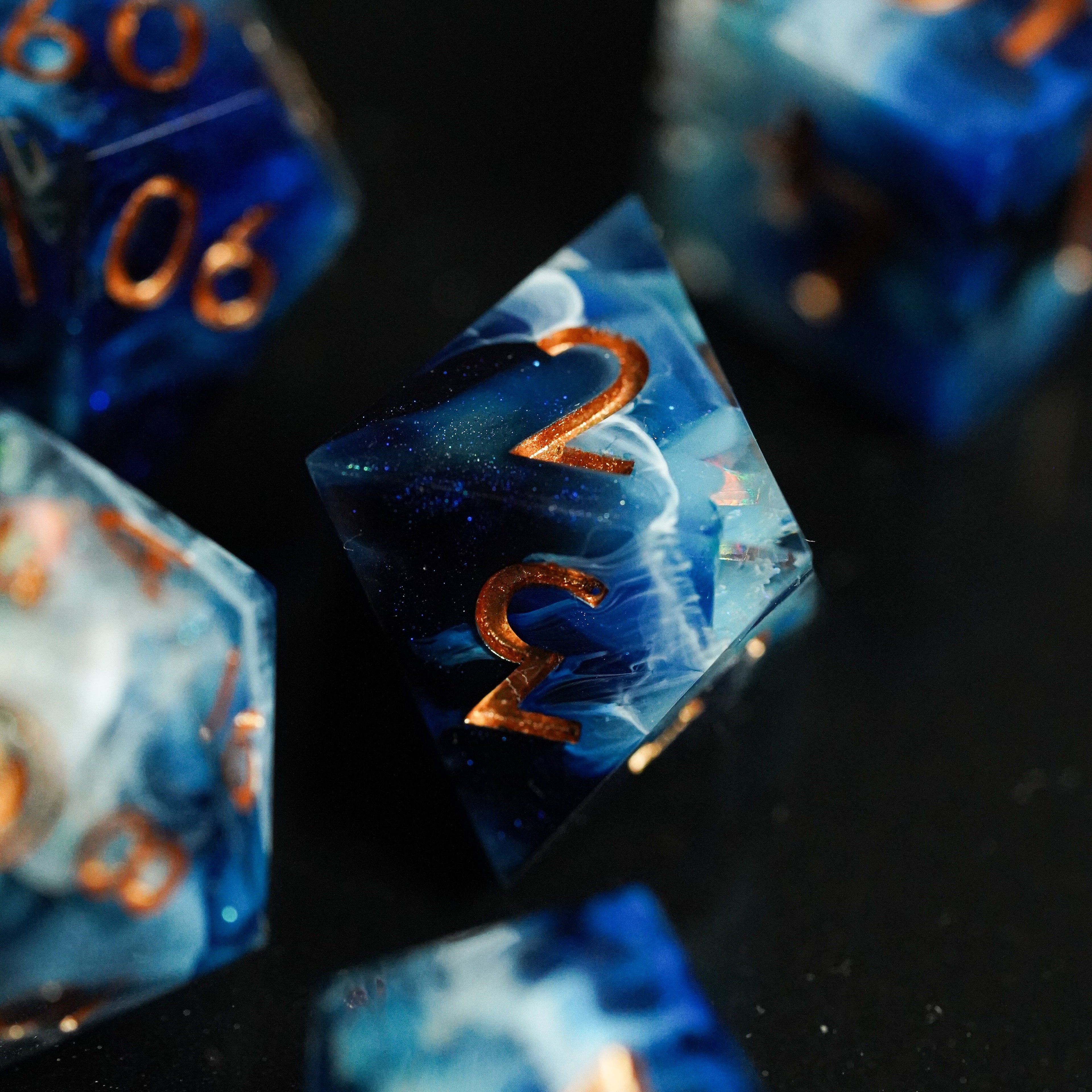 Close-up of blue dice with gold numbers on a black background
