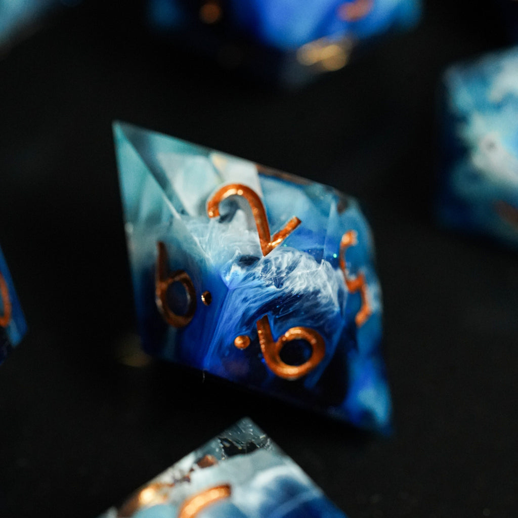 Close-up of blue dice with copper numbers on a dark surface