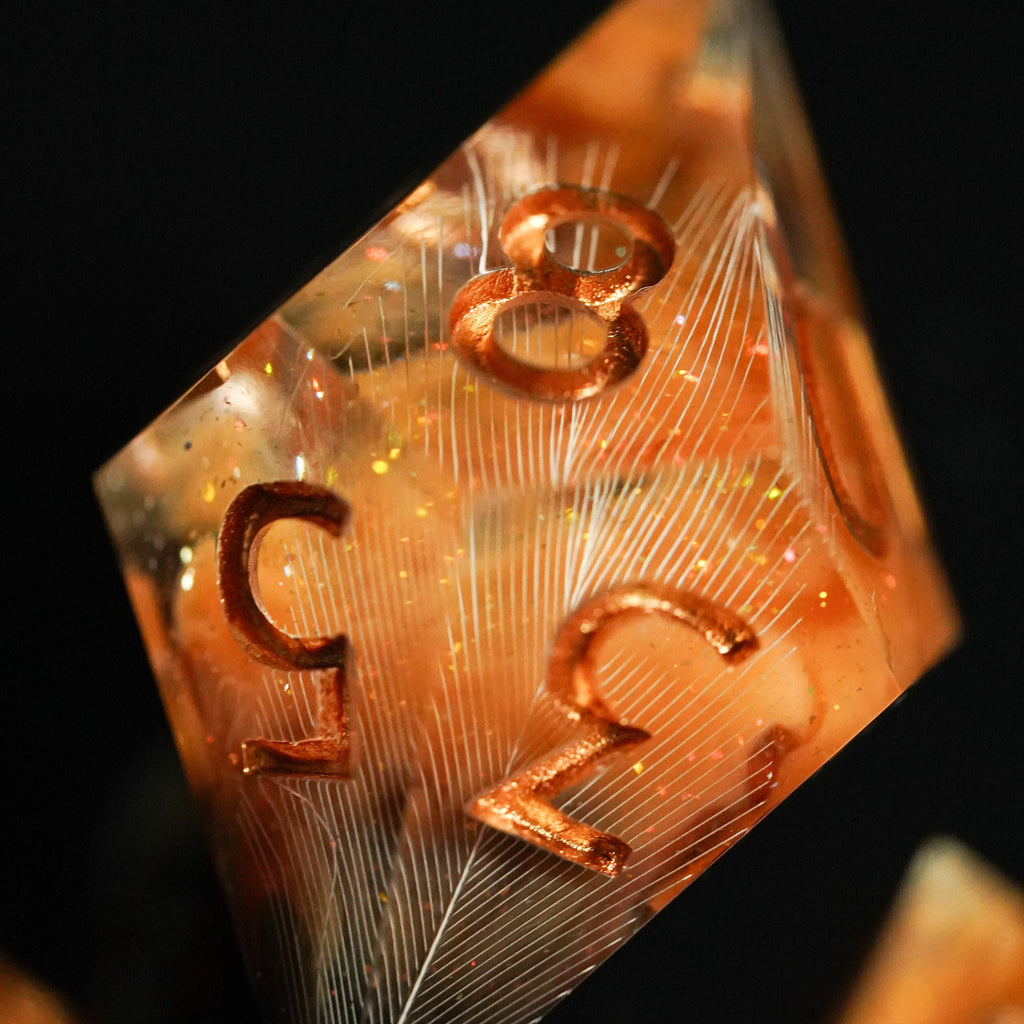 Close-up of a metallic polyhedral dice with numbers on a dark background