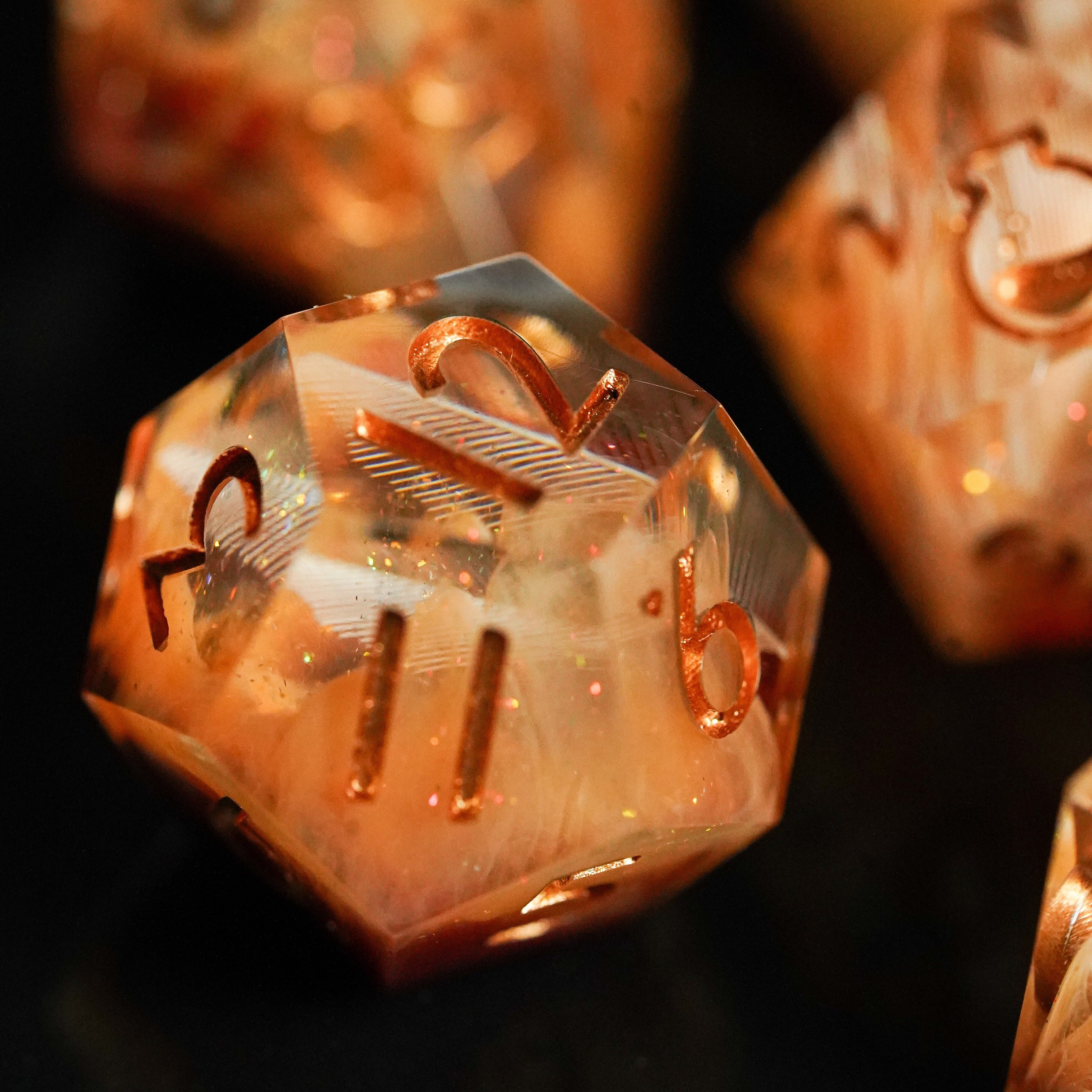 Close-up of a metallic polyhedral dice with numbers on a dark background