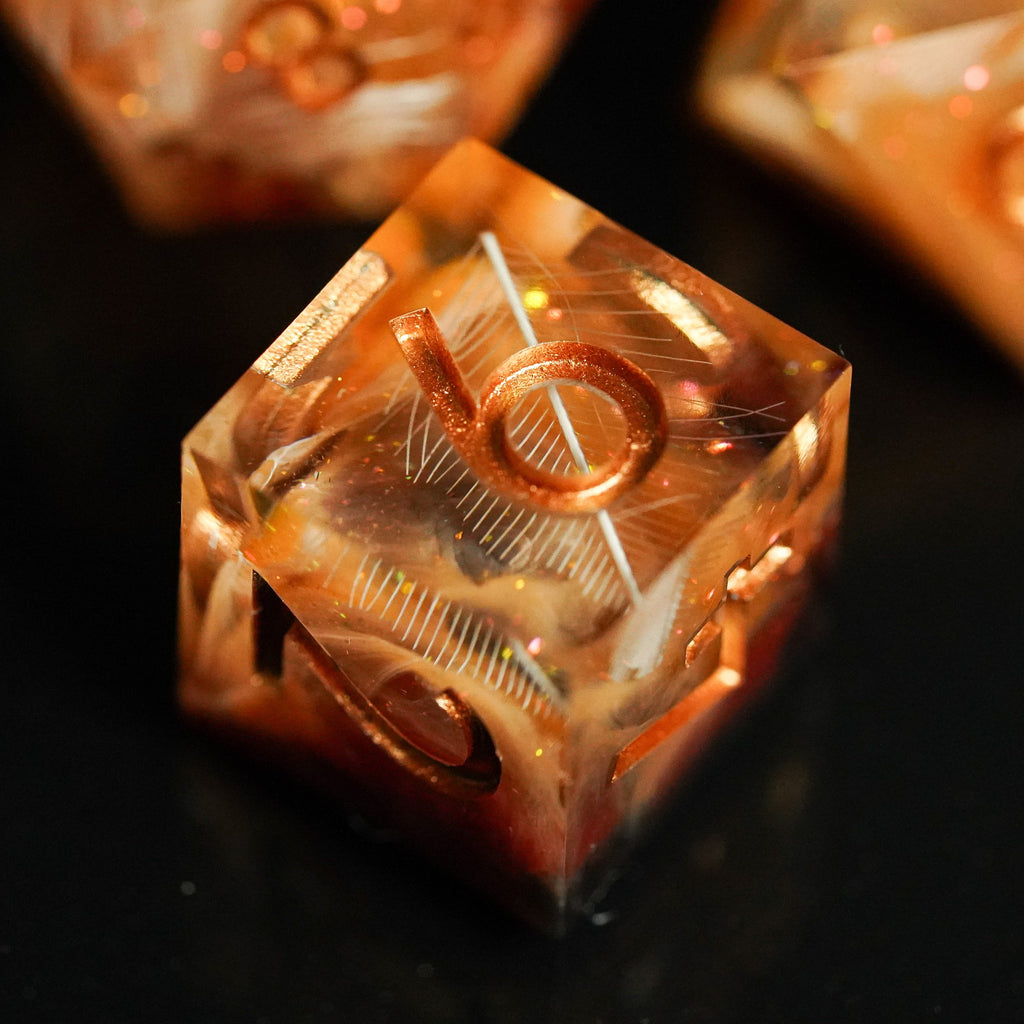 Close-up of a metallic dice with engraved numbers on a dark background