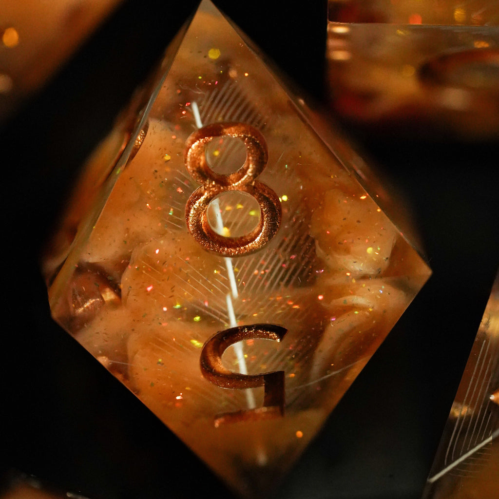 Close-up of a metallic polyhedral dice with the number 8 on one face, against a dark background.