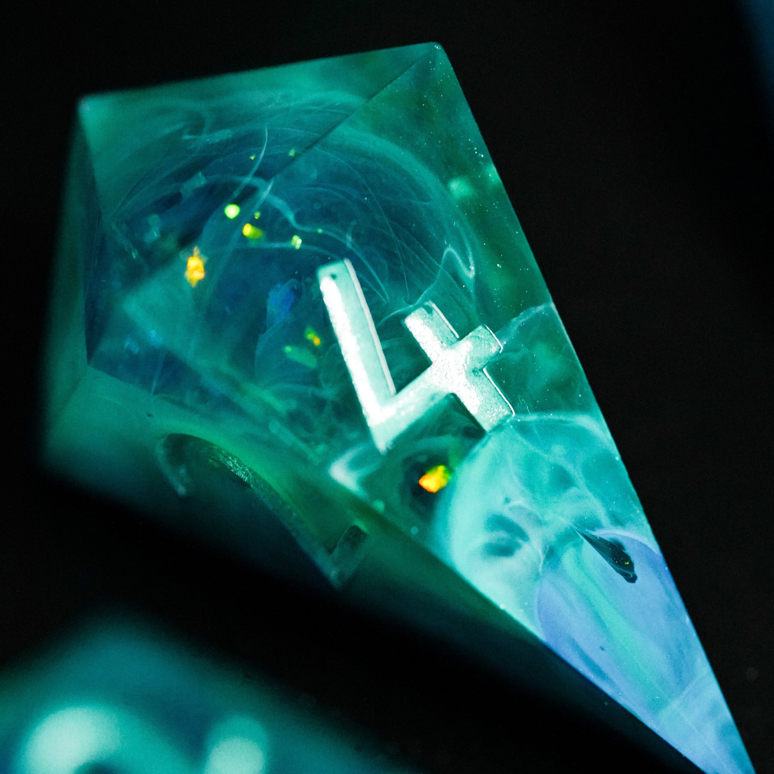 Translucent green polyhedral die with number 4 on a dark background
