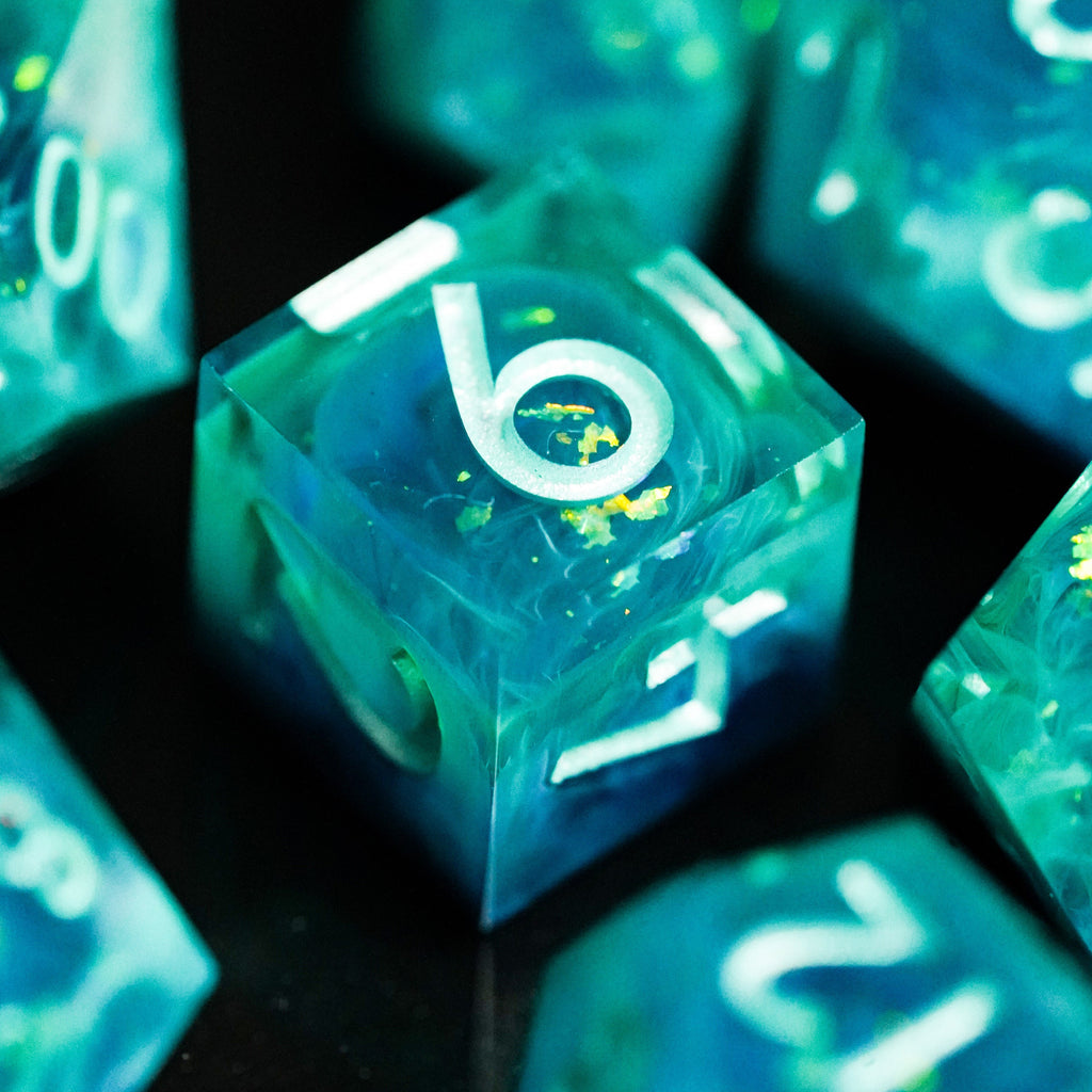 Glowing teal polyhedral dice set on a dark surface