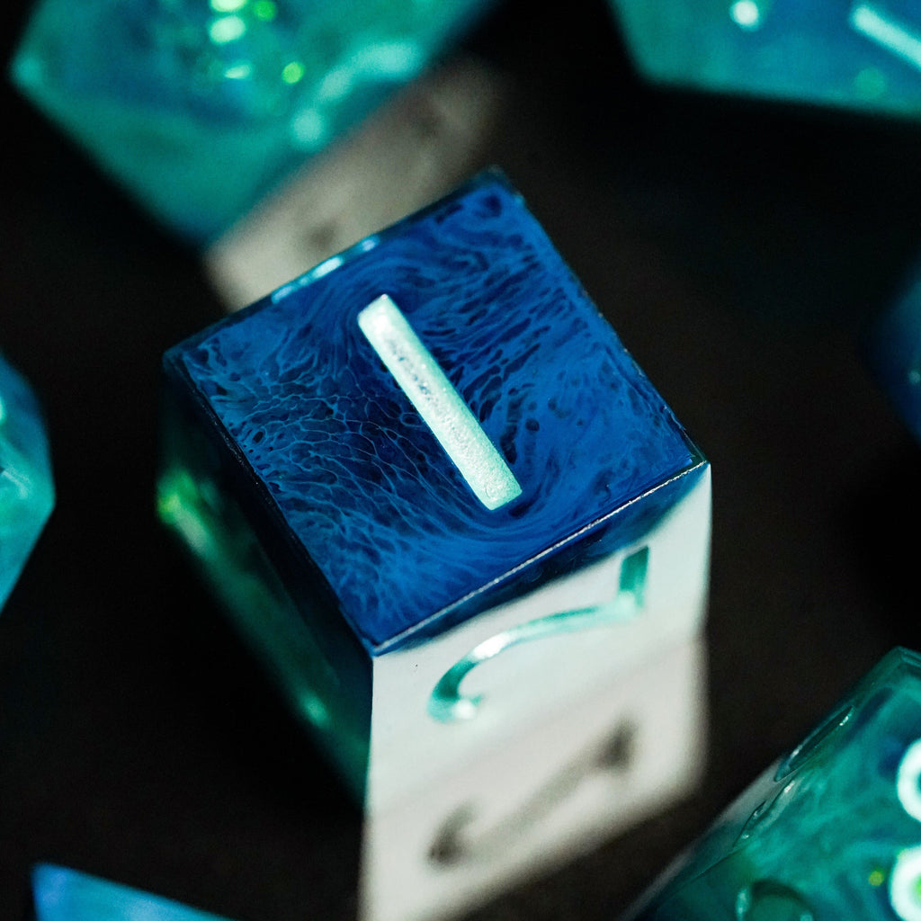 Close-up of blue and green dice with glowing effects on a dark background