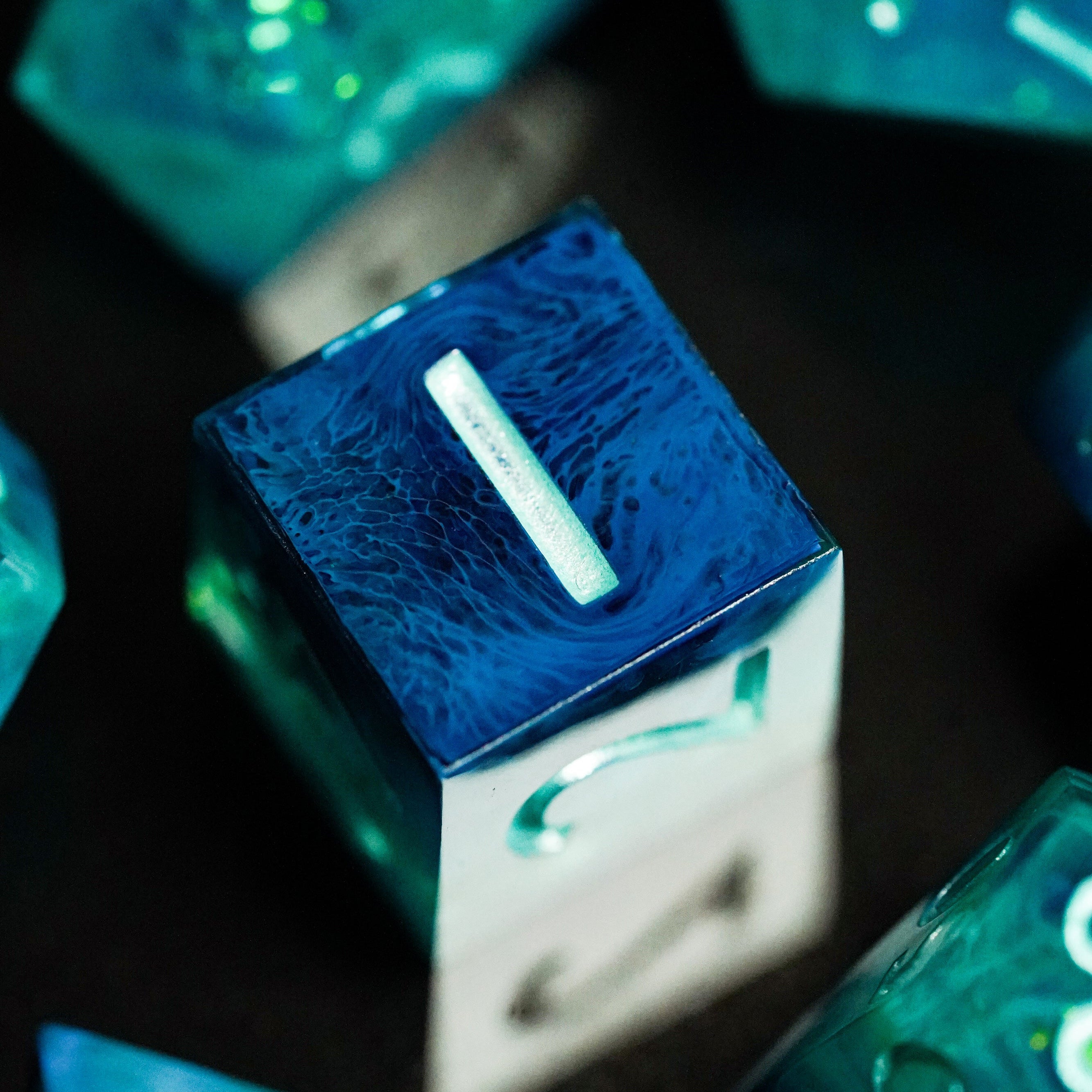 Close-up of blue and green dice with glowing effects on a dark background