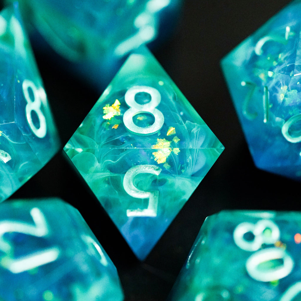 Close-up of teal dice with numbers on a dark background