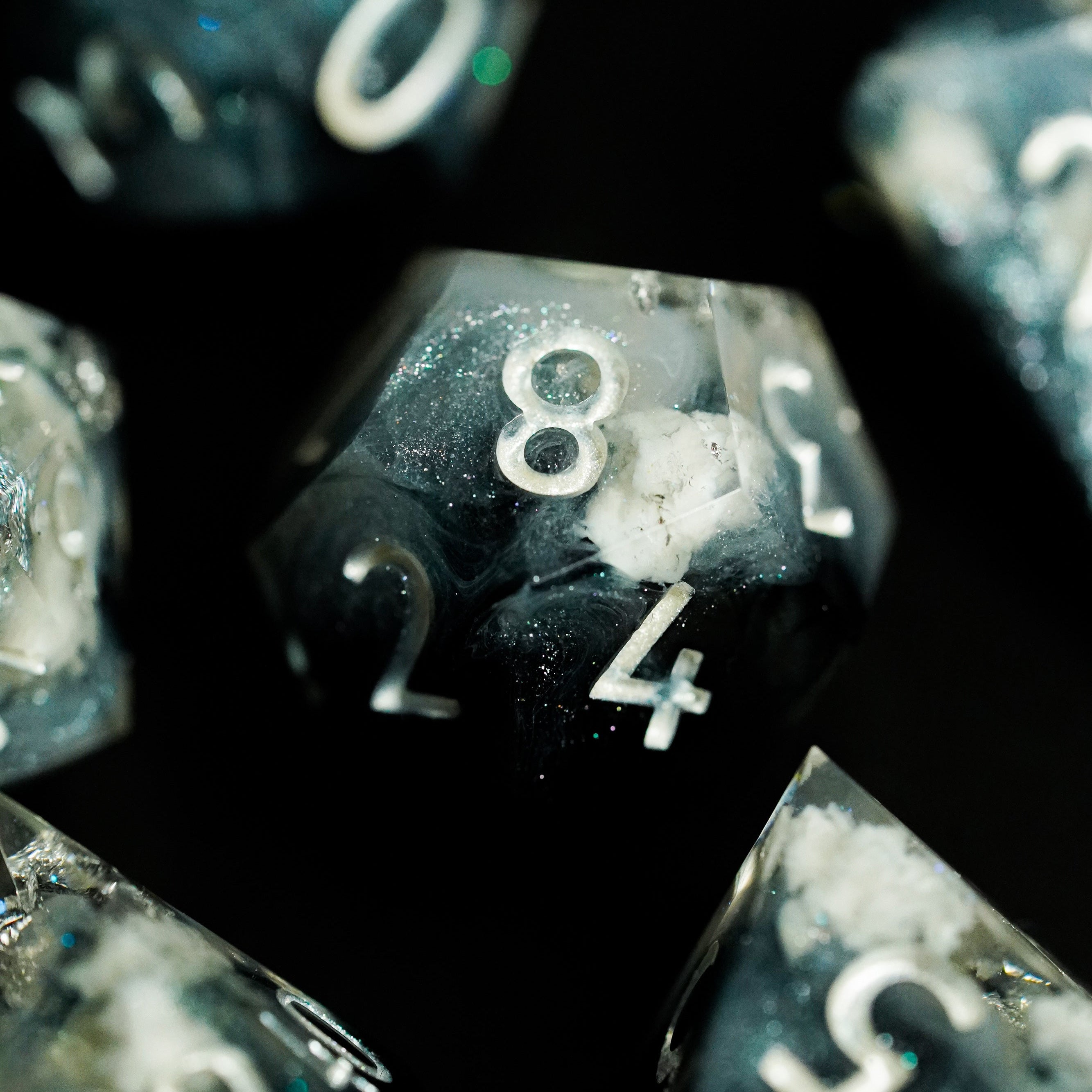 Close-up of polyhedral dice with numbers on a black background