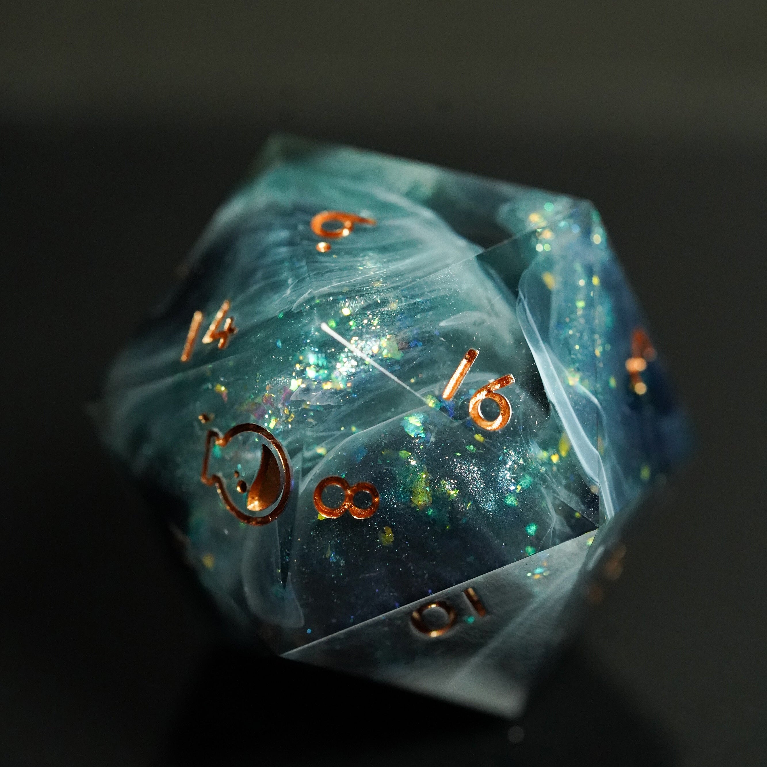 Translucent blue polyhedral dice with gold numbers on a dark background