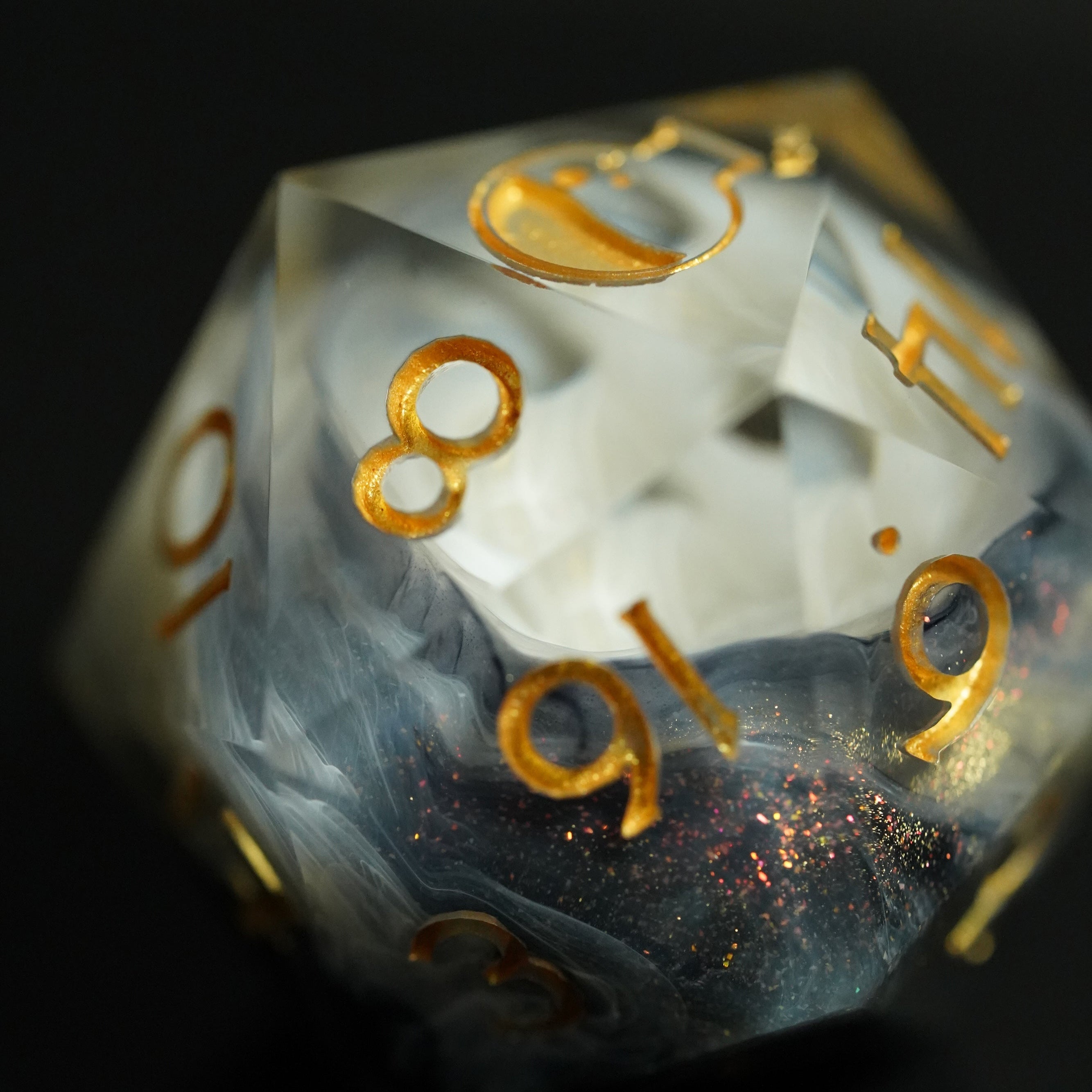 Translucent dice with gold numbers on a black background